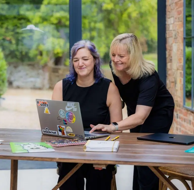 Founder and Director at a desk looking at a laptop.